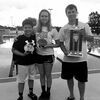 Pictured, left to right: Meghan Watson won the 13-14 Girls High Point Trophy, while Ryan Davis won the 11-12 Boys High Point Trophy at the Taran Sack Invitational, which was held in Parsons, Kan. on June 11 and 12. The TigerSharks new coach, Tyler Kupersmith, is pictured holding the second place team trophy.