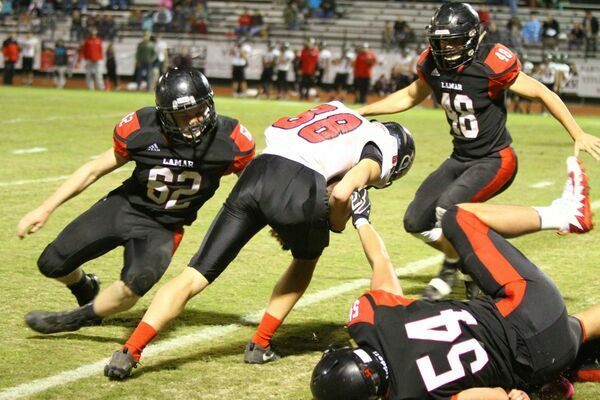 Photo by Terry Redman
Lamar linebackers No. 62 freshman Robert Lawrence and No. 48 senior Michael Henderson, along with No. 54 Morgan Davis, stop this Stockton ball carrier for short yardage in Lamar's 63-6 victory.